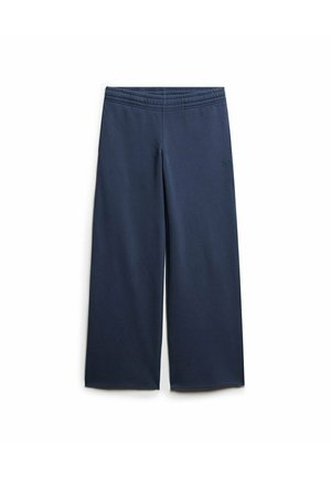 Pantalons larges bleu marine en tissu doux, dotés d'une ceinture élastique et d'un détail logo subtil sur le côté.