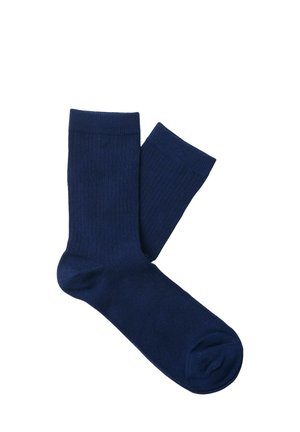 Paire de chaussettes unies bleu marine mi-mollet, posées en chevauchement sur un fond blanc.
