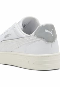Valge nahast sneaker, millel on tekstureeritud hall konts ja mugav tallaga, sisaldab kergelt märgatavat brändimist külg- ja tagaosas.