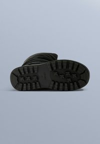 Fekete vízálló hócipő, texturált gumitalppal, rugalmas szárval és fűzős kialakítással a biztos illeszkedés érdekében. Hideg időjárásra alkalmas.