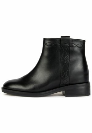 Stivale ankle in pelle nera con punta rotonda, dettaglio cucito sul lato e tacco a blocco basso per supporto. Texture liscia e design minimal.