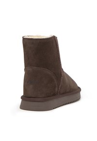 Botín de ante marrón con forro interior suave, suela exterior texturizada y costuras en contraste a lo largo de las uniones. Detalle de logo sencillo en el lateral.