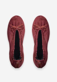 Ballerines en velours bordeaux avec un doublage noir. Elles présentent un bout arrondi, des bords froncés et un nœud décoratif à l'avant.