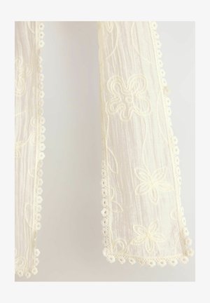 Witte geborduurde stof met bloemmotieven en afgeronde kanten van kant, met een delicate textuur en doorschijnende uitstraling.