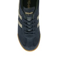 Sneaker in suede blu navy con due strisce grigie, design con lacci, punta arrotondata e suola in gomma chiara. Logo visibile sulla linguetta.