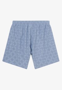 Short en coton bleu clair avec ceinture élastique et motif floral ajouré, présenté à plat sur fond blanc.