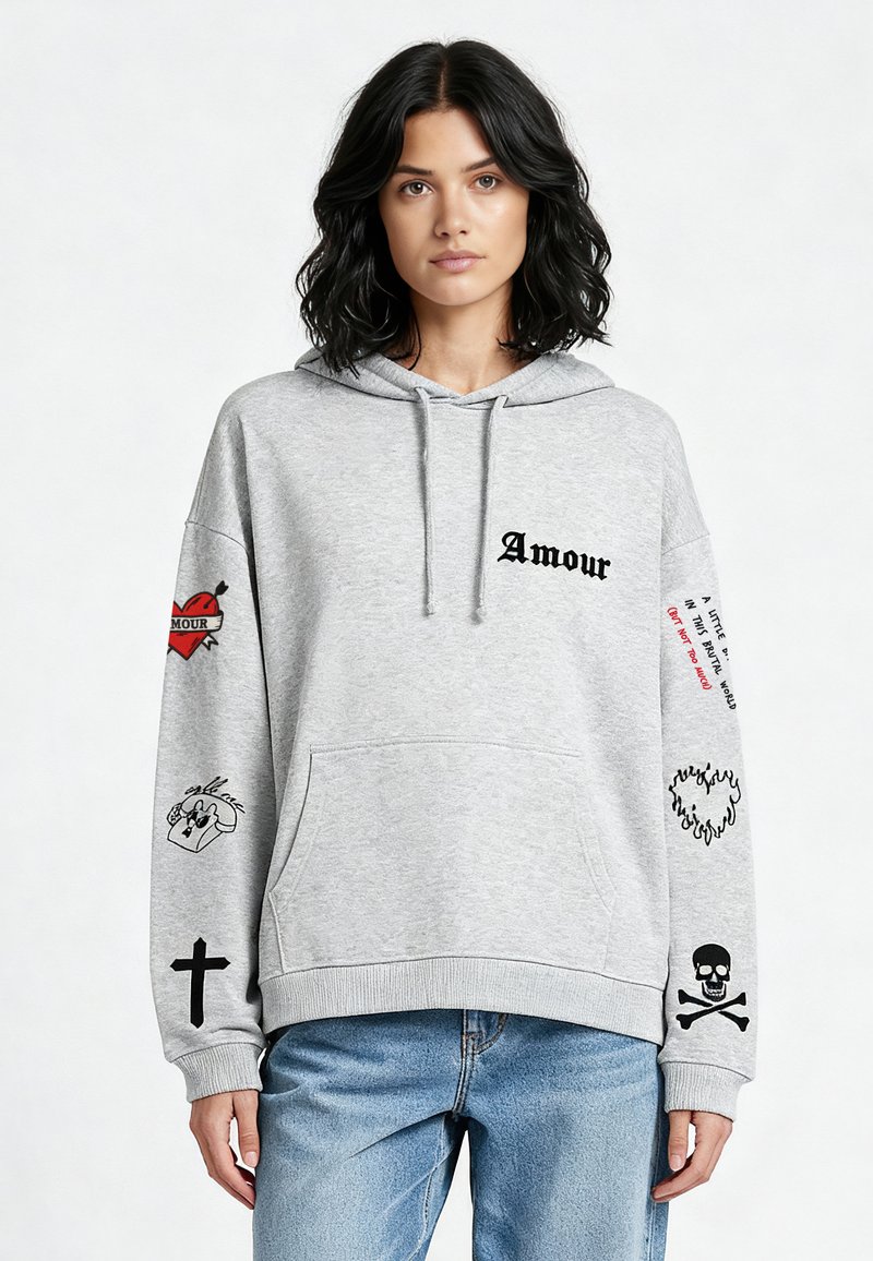 Sweat à capuche gris en mélange de coton, avec le texte 'Amour' en noir, plusieurs impressions graphiques sur les manches, poche kangourou à l'avant et poignets côtelés.