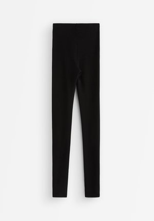 Leggings noirs en tissu extensible, dotés d'une taille haute et d'un design sans coutures. Texture lisse et couverture intégrale.