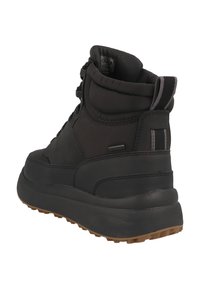Bottines noires avec un dessus lisse, un col rembourré et une semelle en caoutchouc dotée de profondes rainures pour l'adhérence. Rehaussées d'une rayure verticale grise.