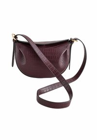 Krokodilgeprägte burgenrote Handtasche mit geschwungener Form, flachem oberen Teil und verstellbarem Tragegurt, der mit goldfarbenen Hardwareelementen versehen ist. Glatte Oberfläche.