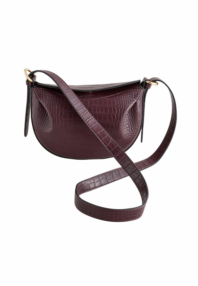 Krokodilgeprägte burgenrote Handtasche mit geschwungener Form, flachem oberen Teil und verstellbarem Tragegurt, der mit goldfarbenen Hardwareelementen versehen ist. Glatte Oberfläche.