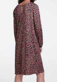 Robe à imprimé léopard avec des manches longues, présentant des nuances de marron, noir et rose. Comprend un détail en trou de serrure à l'arrière et un tissu texturé.