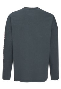 T-paita pitkällä hihalla, tummanharmaa. Pehmeä puuvillakangas, pyöreä kaula-aukko, ja valkoiset painetut tekstit hihoissa. Yksinkertainen, rento malli.