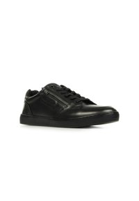 Sneaker in pelle nera con finitura liscia, design con lacci, dettagli con zipper laterale e suola in gomma testurizzata. Classica forma a profilo basso.