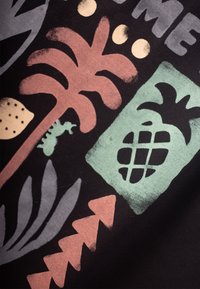 Colorful fabric featuring tropical designs, including a palm tree, pineapple, and geometric shapes in shades of green, pink, and black.