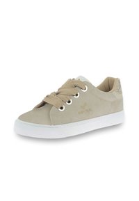 Beige suede sneaker with round toe, white rubber sole, and beige laces. Gold logo on the side and textured detail on the heel.