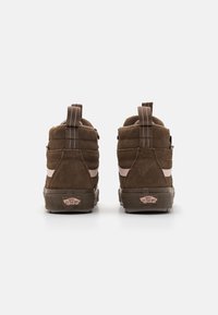 Zapatillas altas de ante marrón con rayas rosa claro, material texturizado, talón reforzado y logo de Vans en la lengüeta del talón.