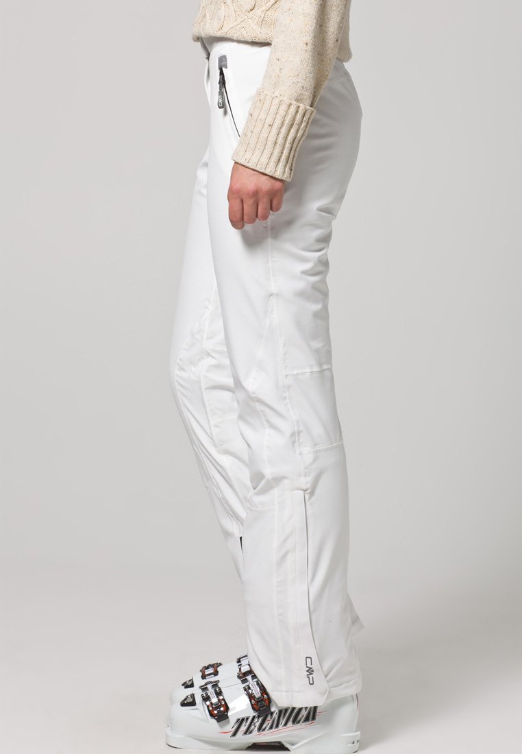 Witte skibroek met een slim fit, ritszakken en versterkte naden. Textuurstof met een lichte glans, gecombineerd met skischoenen.