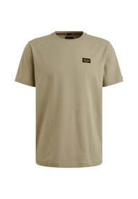 Camiseta de algodón color caqui con cuello redondo. Presenta una pequeña etiqueta negra en el lado izquierdo del pecho y mangas cortas. Textura suave, corte regular.