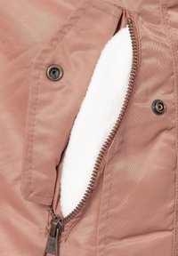 Roze stoffen jack met een zachte witte fleece voering, voorzien van een metalen rits en drukknoopdetails. Gestructureerd ontwerp met een gladde textuur.