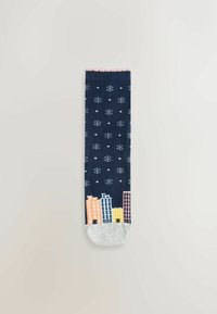 Mörkblå strumpor med vita snöflingor, med en stadssilhuettdesign i rosa, gult och ljusblått vid tån, och en grå häl.