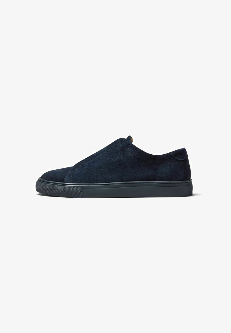 Suede slip-on sneaker in navy blue with a smooth texture. Features a contrasting dark rubber sole and minimalistic design without laces.