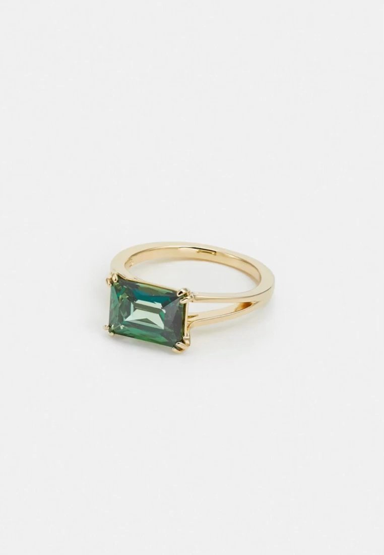 Bague en or ornée d’une pierre précieuse verte rectangulaire maintenue par quatre griffes, sur un fond blanc uni.