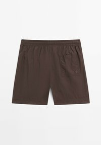 Bruine, lichte shorts met een elastische tailleband, voorzien van een achterzak en een klein oogje detail. Textuurstof met een ontspannen pasvorm.