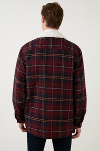 Cămașă flanel cu carouri roșii și bleumarin, cu guler din sherpa alb, mâneci lungi și croială lejeră. Are mansete cu nasturi și un tiv curbat.