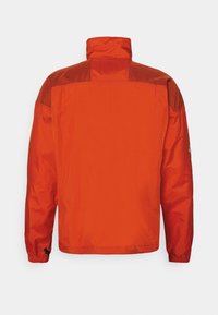 Veste orange vif à manches longues et col montant, vue de dos sur un fond clair uni.