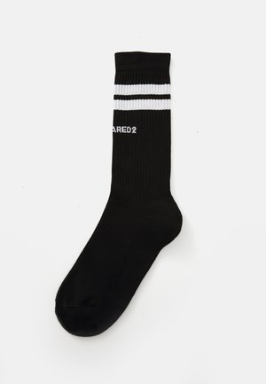 Chaussettes de crew noires avec texture côtelée, présentant deux bandes blanches en haut et le logo "DARED2" en blanc sur le côté.