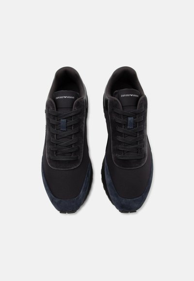 Paire de baskets noires Emporio Armani avec embouts en suède bleu foncé et lacets noirs, vues de dessus sur fond blanc.