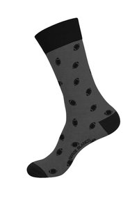 Chaussette en coton gris avec un cuff côtelé noir et un motif répétitif de formes ovales noires ressemblant à des ballons de rugby.