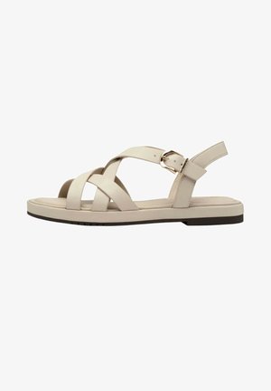 Sandalo piatto beige con cinturini incrociati, fibbia regolabile e design slingback su suola scura.