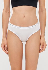 Bieli kokvilnas apakšbikses ar zemu vidukli un elastīgu jostu, kas rotāta ar drukātu logo. Gluda tekstūra un minimāls dizains.