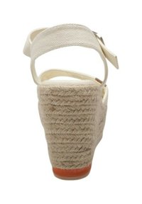 Sandalo con zeppa con tacco in juta intrecciata beige, cinturino in tessuto alla caviglia e suola piatta e testurizzata. Il tacco è alto circa 7 cm.
