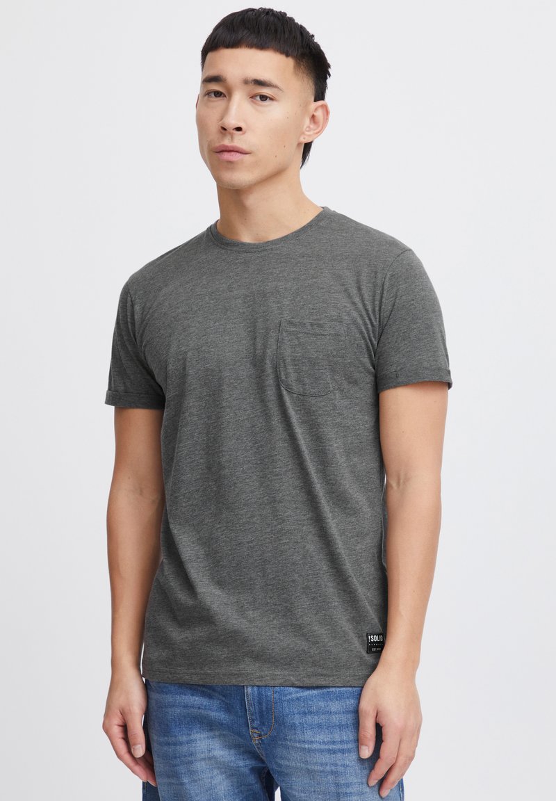 Grå kortærmet t-shirt i blødt stof med rund hals og en lomme på venstre bryst. Har en syet kant og et syet label i bunden.
