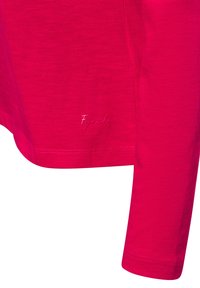 Langärmliges Hemd in leuchtendem Pink. Hergestellt aus weichem Stoff mit glatter Textur. Verfügt über einen abgerundeten Saum und ein dezentes gesticktes Logo am unteren Rand.