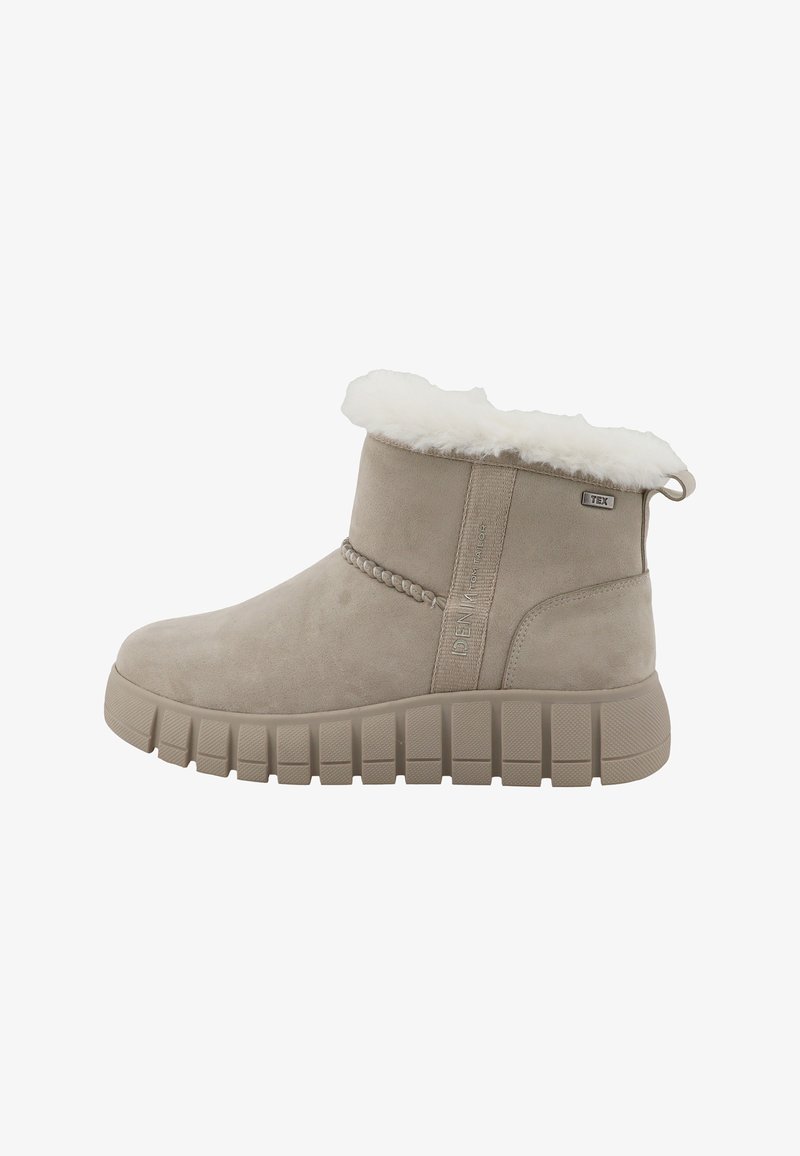 Bottine beige avec semelle épaisse à crampons, doublure douce en fausse fourrure à l'ouverture et petite boucle en tissu au talon pour un enfilage facile.