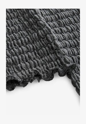 Teksturela temno siva tkanina z gubanim vzorcem; ima valovite robove in mehko, puhasto teksturo za prijeten otip.