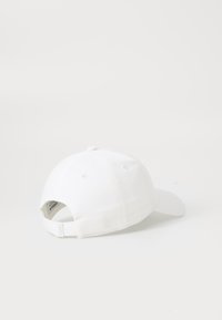 Witte honkbalpet met een gebogen klep, gemaakt van katoen. Heeft een verstelbare band aan de achterkant en ventilatiegaten aan de zijkanten.