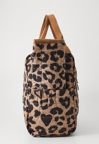 Zaino leopardato in tonalità beige e nero, con una texture trapuntata, realizzato in tessuto e dotato di un robusto manico superiore marrone. Dettaglio con zip laterale.