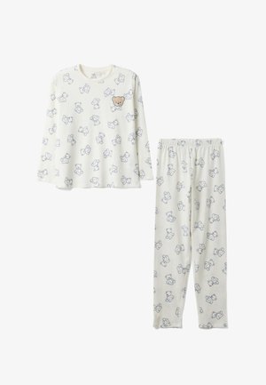 Kinderpyjama in crème met lange mouwen, met blauwe teddybeercontouren en één effen bruine teddybeer op de borst van het bovenstuk.