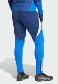 Blauwe sportbroek met een combinatie van donkerblauwe en lichtblauwe panelen, witte accenten, een aansluitend ontwerp en ritsen bij de enkels.