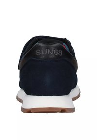 Sneaker blu scuro con suola bianca e battistrada marrone, vista da dietro, con "SUN68" impresso sulla linguetta nera del tallone.