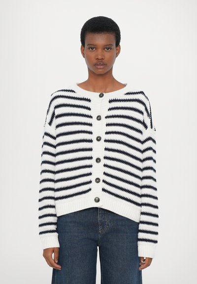 Knitted cardigan in white with black horizontal stripes, featuring large round buttons, a crew neckline, and ribbed cuffs and hem.