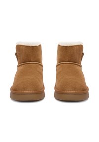 Botine din suede maro cu interior pufos, vârf rotund, talpă joasă și plată, cu un detaliu cusut de-a lungul părții superioare. Fără logo-uri vizibile.