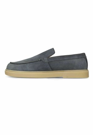 Grijze suède instap loafer met bruine rubberen zool, ronde neus en lage hak, zijaanzicht.