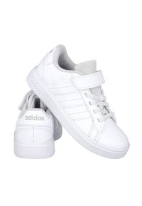 Zapatillas blancas con una parte superior de cuero suave, puntera redonda, acentos en gris, cierre de cordones y correa, y suela de goma texturizada. Marca en el talón y la lengüeta.