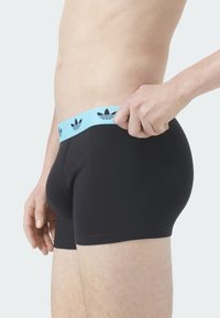 Czarne bokserki z jasnoniebieskim pasem w talii z czarnym logo. Miękki materiał, dopasowany krój i długość do połowy uda.